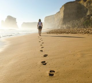 woman's footsteps walking on the beach